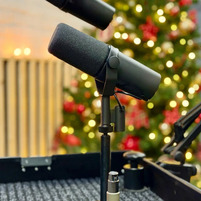 Black sm7b dynamic recording microphone with foam windscreen mounted on stand for live vocals performance