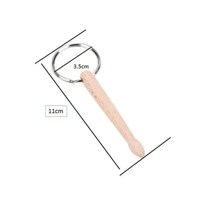 A light-colored wood drumsticks percussion key ring with a smooth tapered handle and silver metal ring for drum sticks keychain use