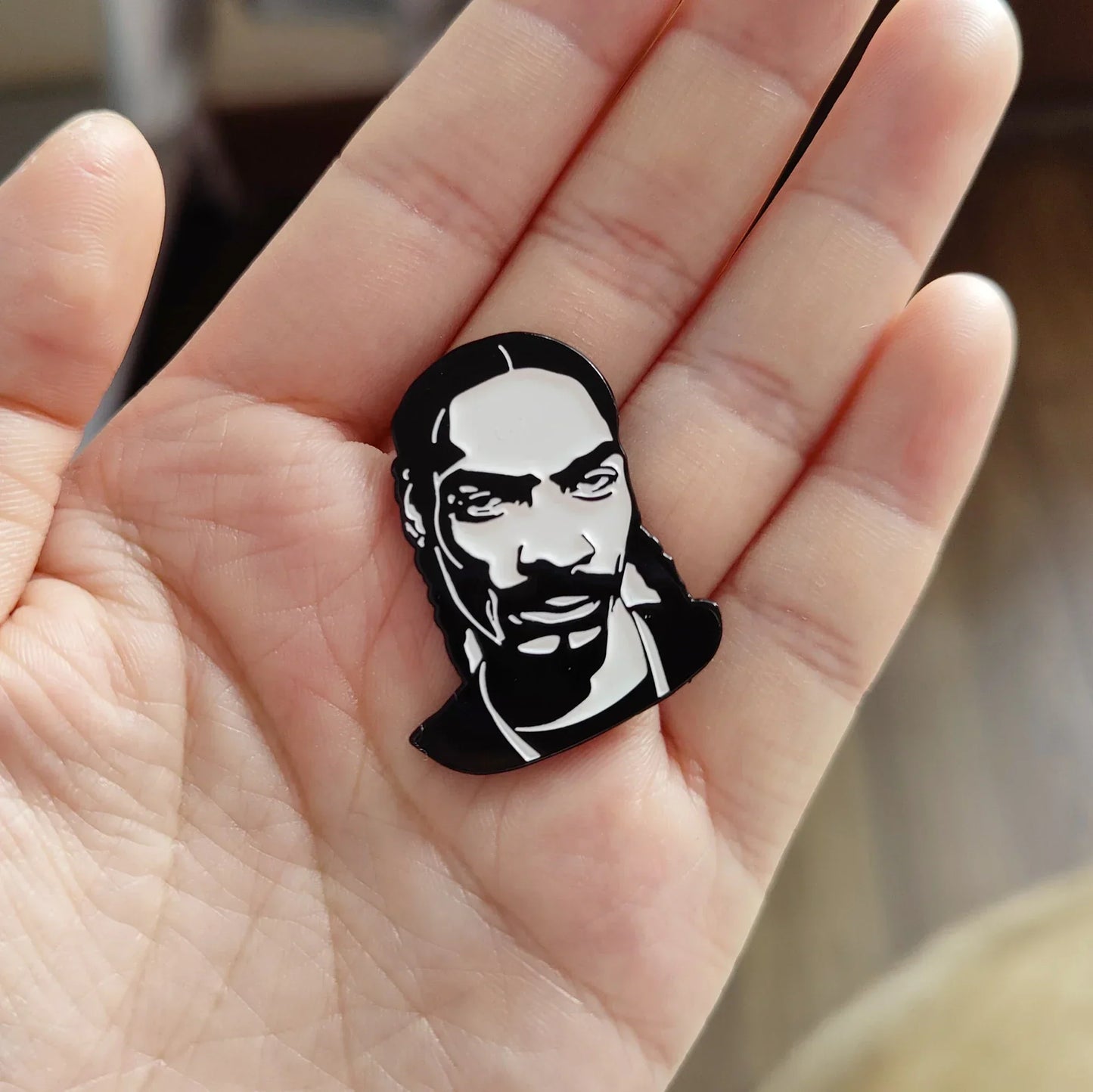 Black and white enamel rapper enamel pin featuring stylized snoop dogg as hip hop godfather badge jewelry gift