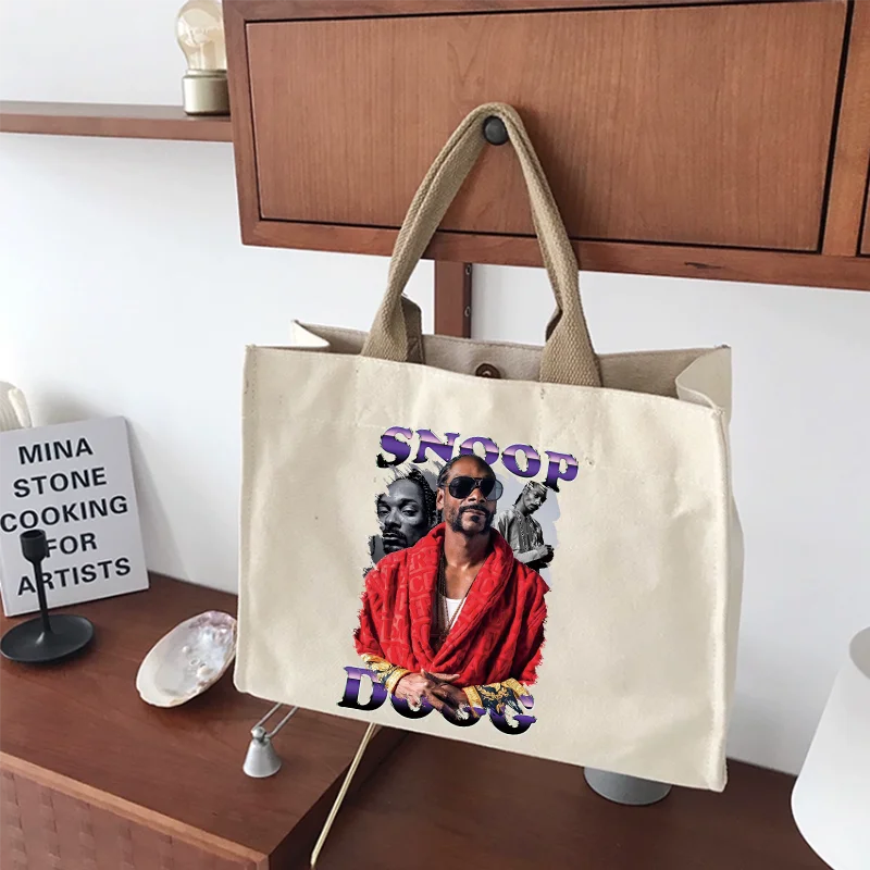 Beige canvas tote bag with vibrant snoop dogg hip hop godfather graphic in red and purple text suitable for ironing pad use