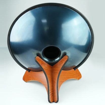 A sleek dark blue metallic handpan with black rim on an orange solid wood drum portable handpan storage stand