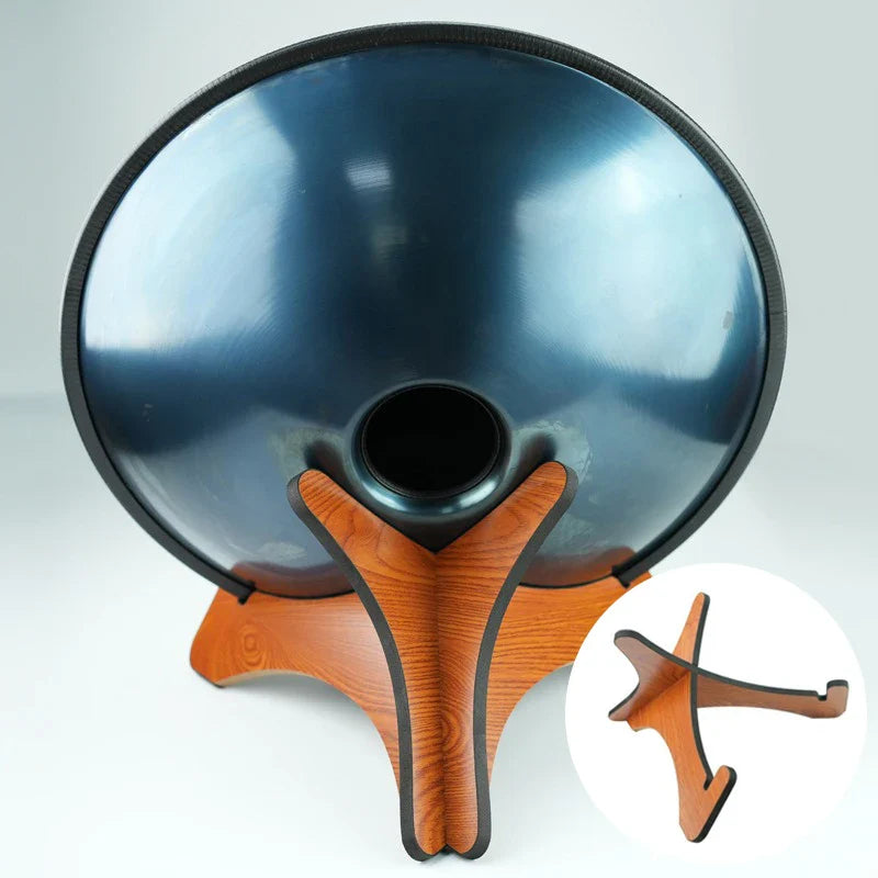 Shiny dark blue handpan resting on a solid wood drum stand for portable handpan storage and tongue drums display