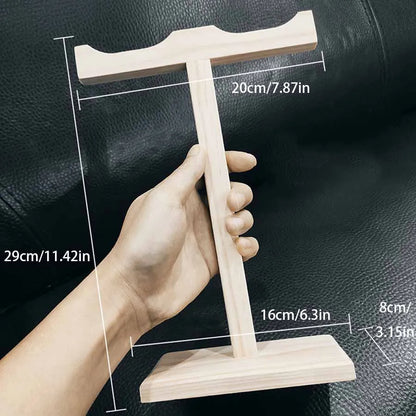 Light-colored solid wood headphone stand t-shaped with flat top and rectangular base for universal noise reduction use