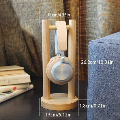 Light wood solid wood headphone stand with circular base and vertical supports holding beige leather strap headphones