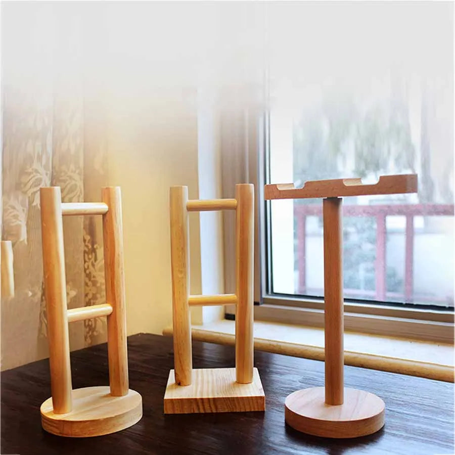 Three minimalist solid wood headphone stands with natural light wood finish and universal noise reduction design