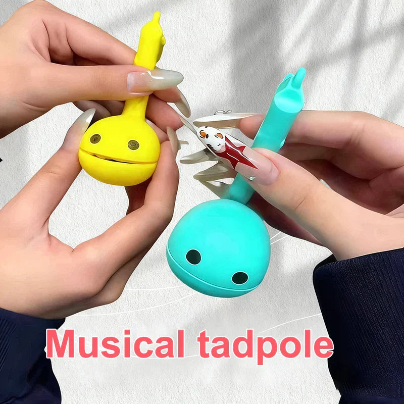 Yellow and teal smooth plastic musical notes otamatone mini electronic toys with smiling faces for creative sound-producing fun