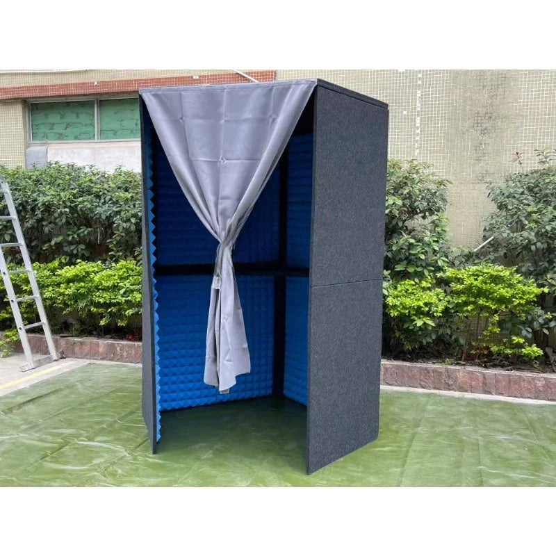 A gray fabric curtain tied in a bow hangs on a black and blue portable home studio professional sound table booth