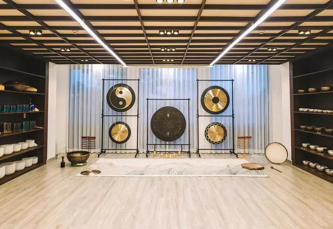 Square steel stand with wheels supports five gongs including black and gold designs with gong adjustable height for percussion musical instrument use