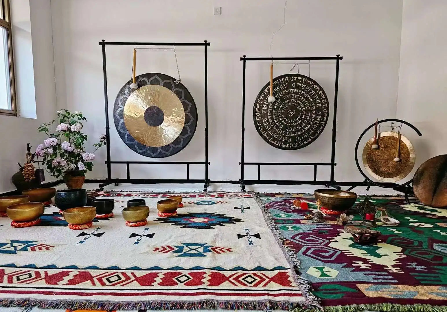 Two large ornate gongs hang on a black square steel stand with wheels featuring gong adjustable height for percussion musical instruments