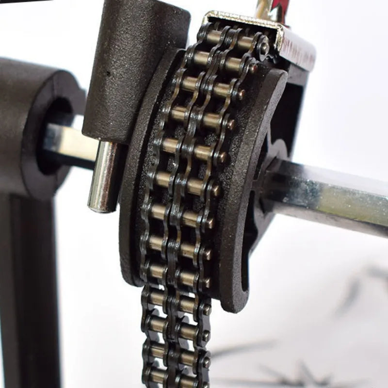 Black metal roller chain mounted on mechanical sprocket assembly for stand drum single step hammer aluminium practice pad