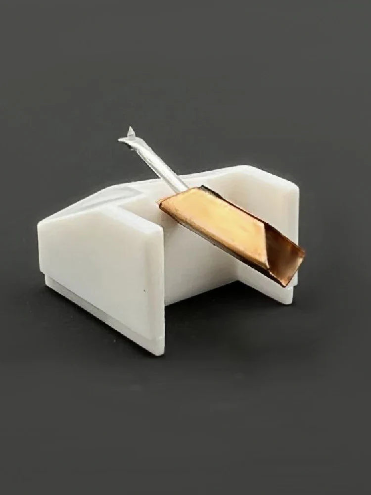 A sleek white plastic stanton phono head replacement needle holder with gold needle and silver stem for essential dj turntable use