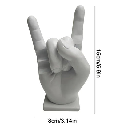 White resin statue of a hand making the rock on sign used as a modern drum stick holder and display stand for home decor