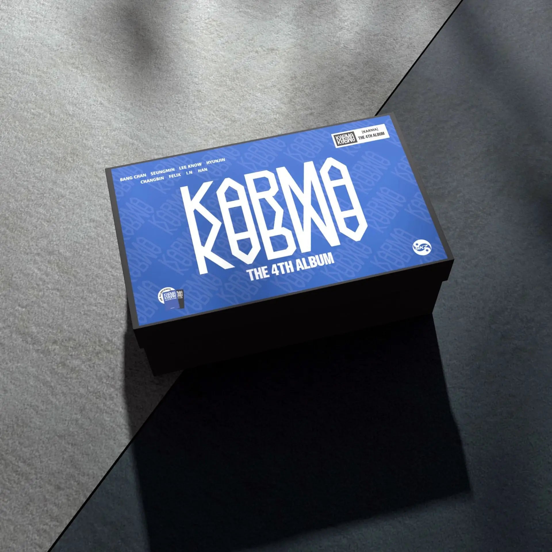 Blue and black rectangular stray kids gift box with bold white korma lettering featuring karma felix huang and huang xuanchen skzoo