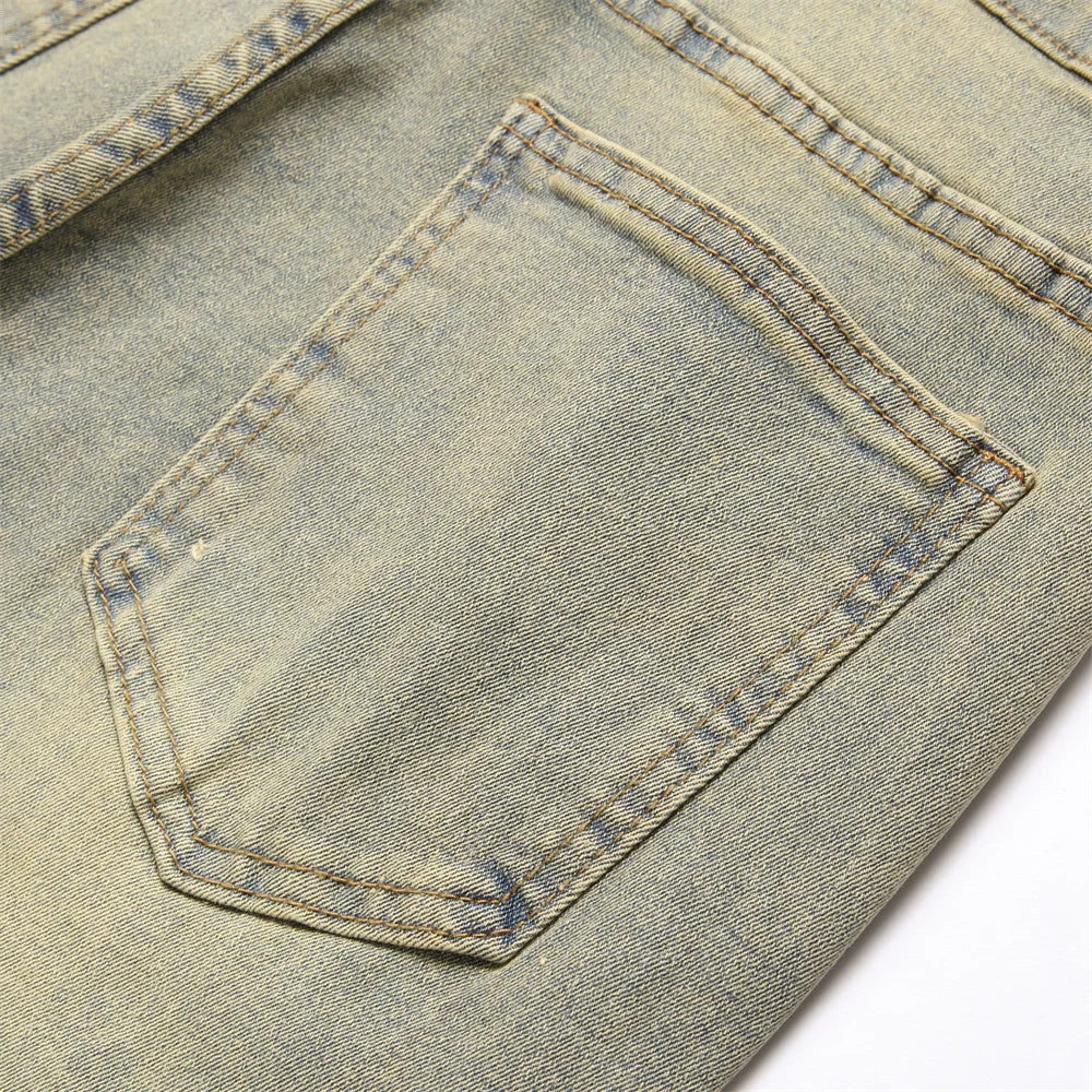 A faded light blue denim pocket with visible stitching on streetwear retro style spliced slim jeans with hip hop holes