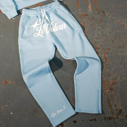 Light blue sweatpants with white embroidered le voleur logo and less than 2 text near cuff in y2k clothes mens piece set y2k