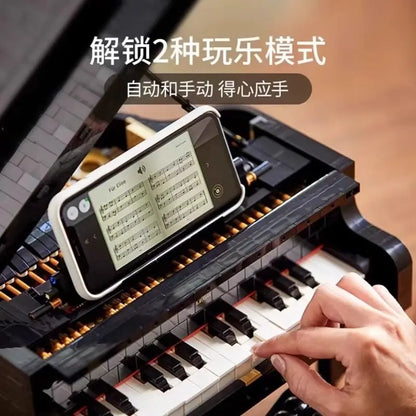 Black and white idea assembly block piano model with golden keys and smartphone display on lid for sheet music