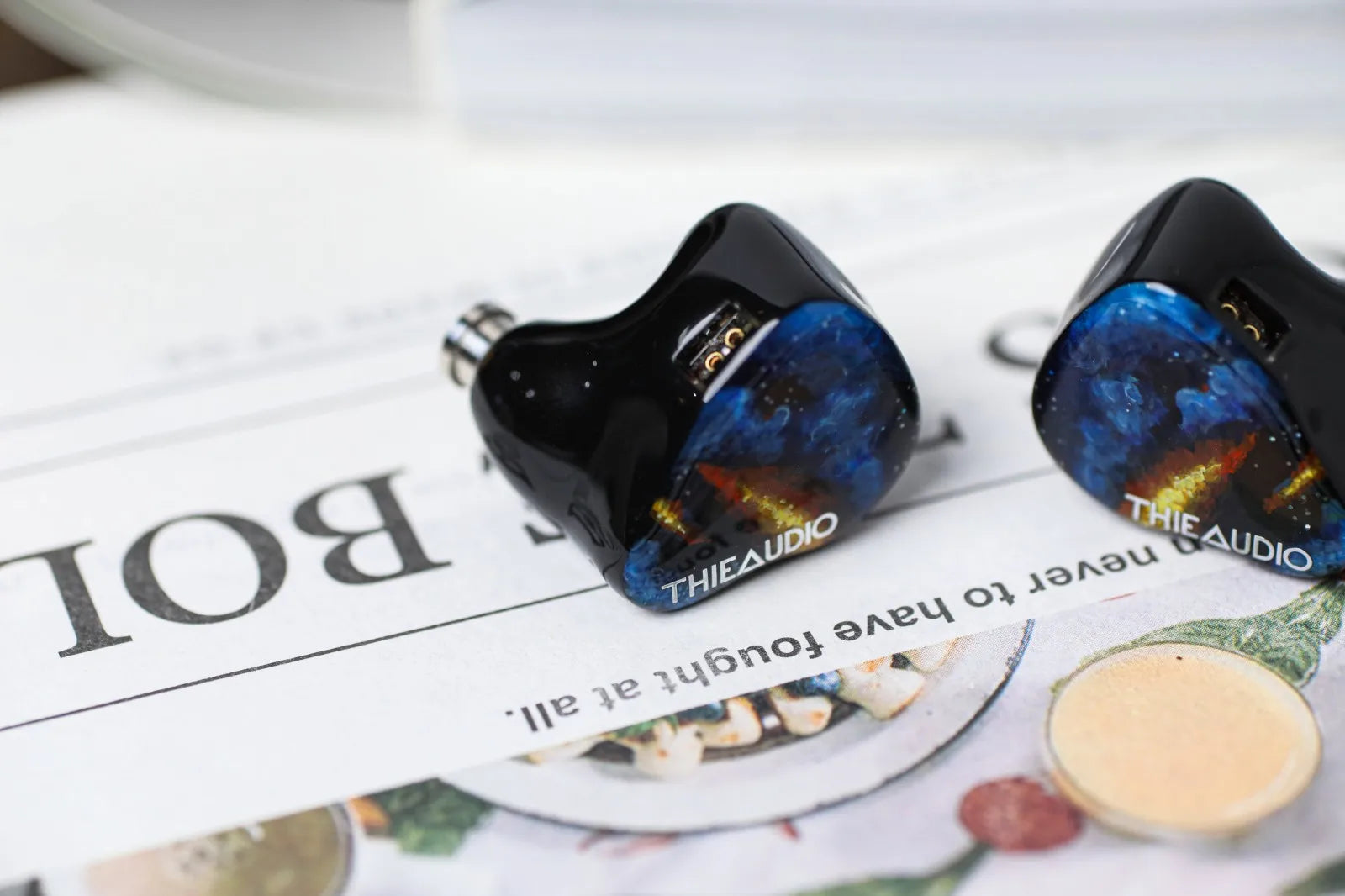 Black thieaudio origin quadbrid iem hifi headphones with glossy vibrant blue orange gold patterns for audiophiles musicians