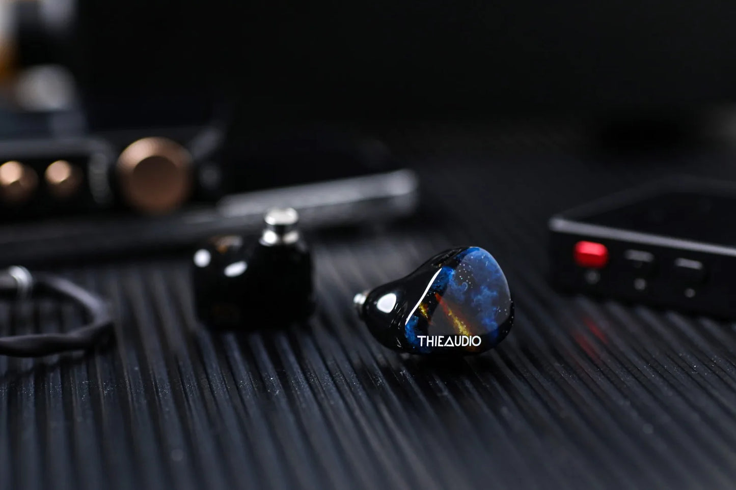 Sleek glossy black thieaudio origin quadbrid iem hifi with vibrant blue gold iridescent finish for audiophiles musicians