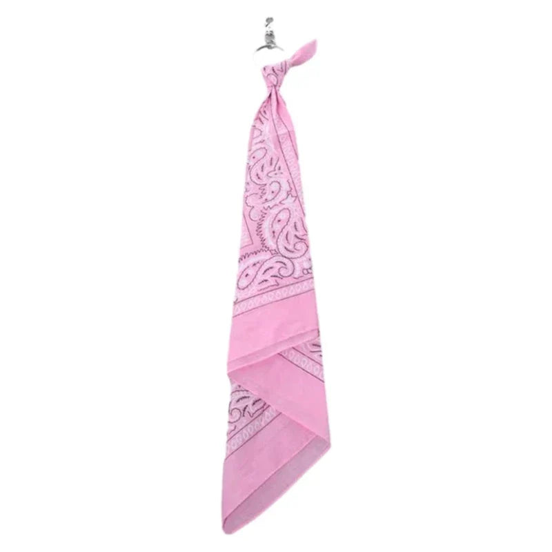 A pink paisley patterned square scarf tied in a knot, complementing trendy cashew print pants chain hip hop style accessory