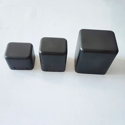 Three black matte plastic cubes as tube amplifier case isolation shrouds with base transformer cover accessories