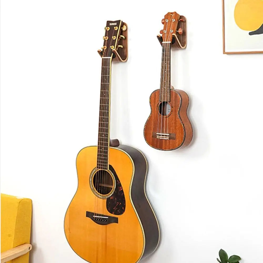 A warm-toned acoustic guitar with natural wood finish mounted on a unique design wooden bracket guitar hanger mount bass storage