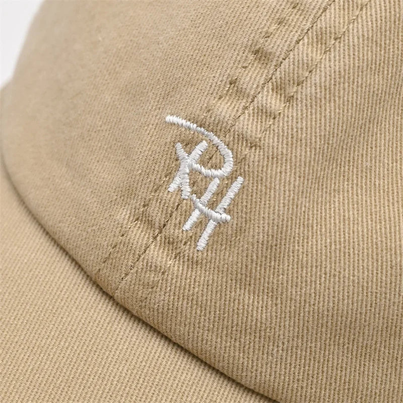 A beige unisex RH letter baseball cap with white embroidery designed as a summer casual hat for outdoor shade adjustable fit