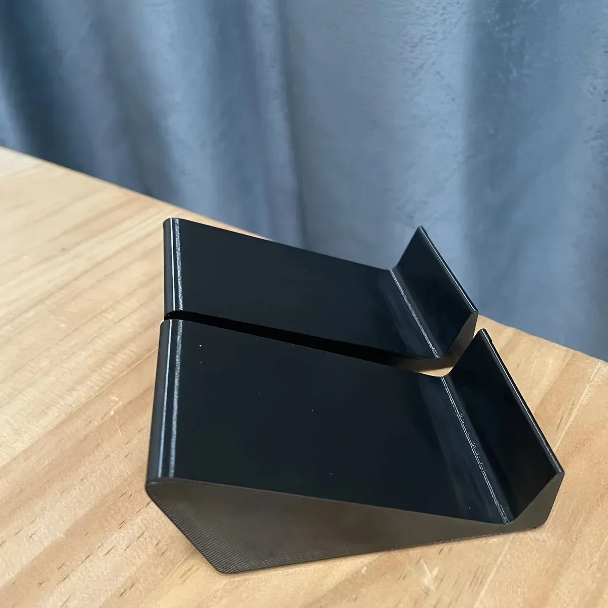 Black plastic universal adjustable soundbar stand base with sleek angular design for multi-brand soundbar setup