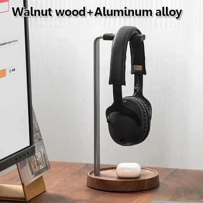 Black over-ear headphones with leather-like headband on a universal wooden headphones stand walnut and aluminum alloy holder hanger desktop
