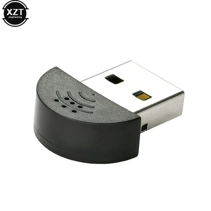 Black and silver usb 2.0 mic audio adapter with curved textured housing and speaker-like perforations for portable studio speech use