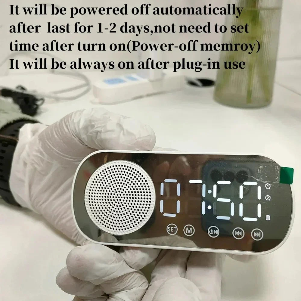 Silver mirror digital alarm clock with led display and circular speaker grille acting as wireless speaker subwoofer desktop music player