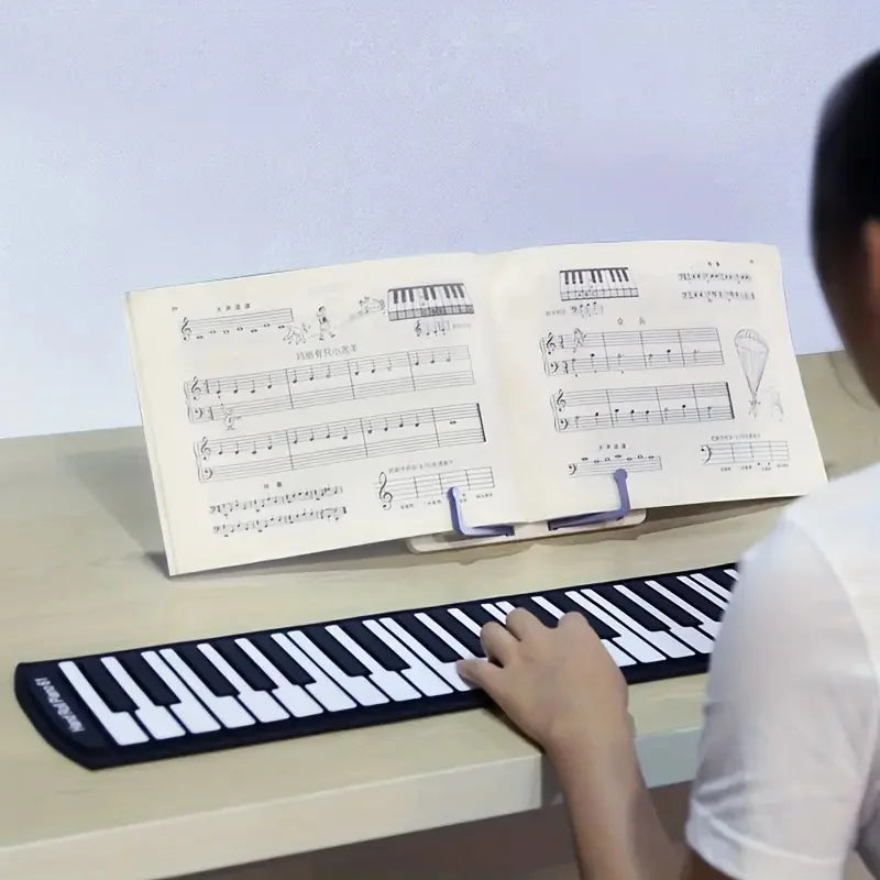 Black and white flexible keyboard played on an adjustable music sheet stand with portable reading bookshelf features
