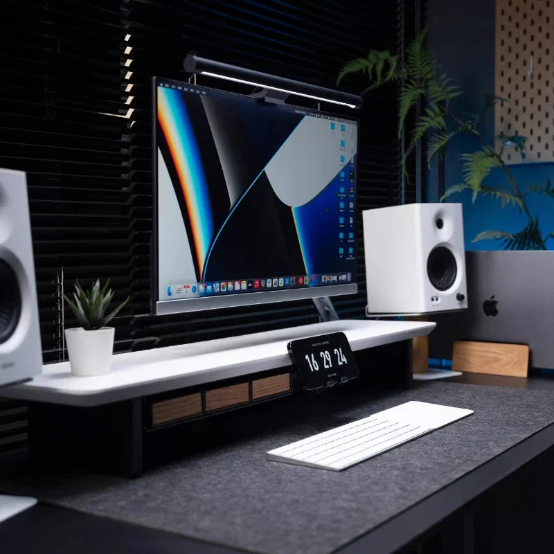 Black monitor on walnut oak wood speaker stand with metal base modern desk organizer for home office audio storage