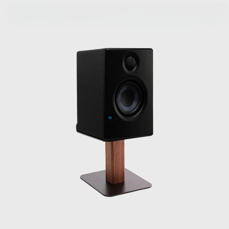 Black studio monitor speaker on walnut oak wood speaker stand with metal base modern desk organizer for home office