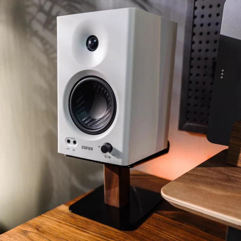 White edifier speaker with black carbon fiber cone on walnut oak wood speaker stand with metal base modern desk organizer