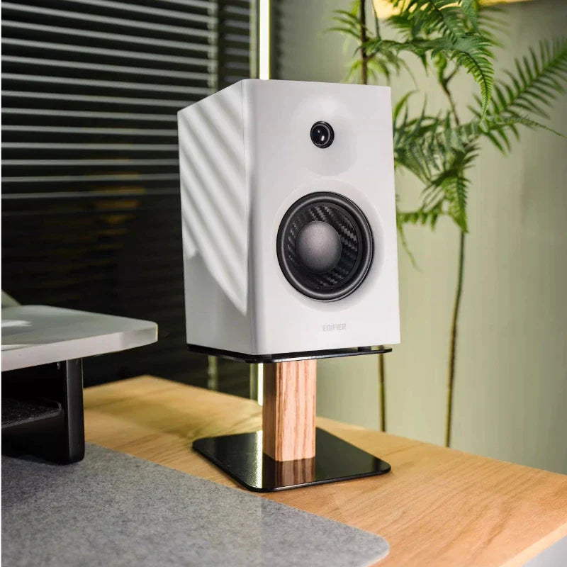 White studio monitor with black carbon fiber cone mounted on walnut oak wood speaker stand for modern desk organizer