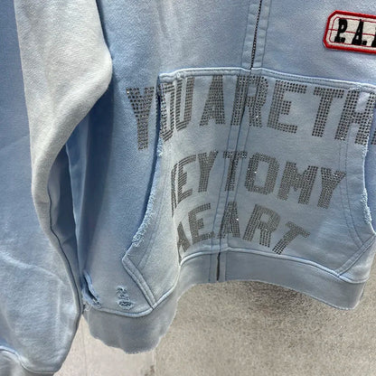 Light blue denim-style zip-up hoodie with distressed details and rhinestone lettering by washed blue paly hoodies men