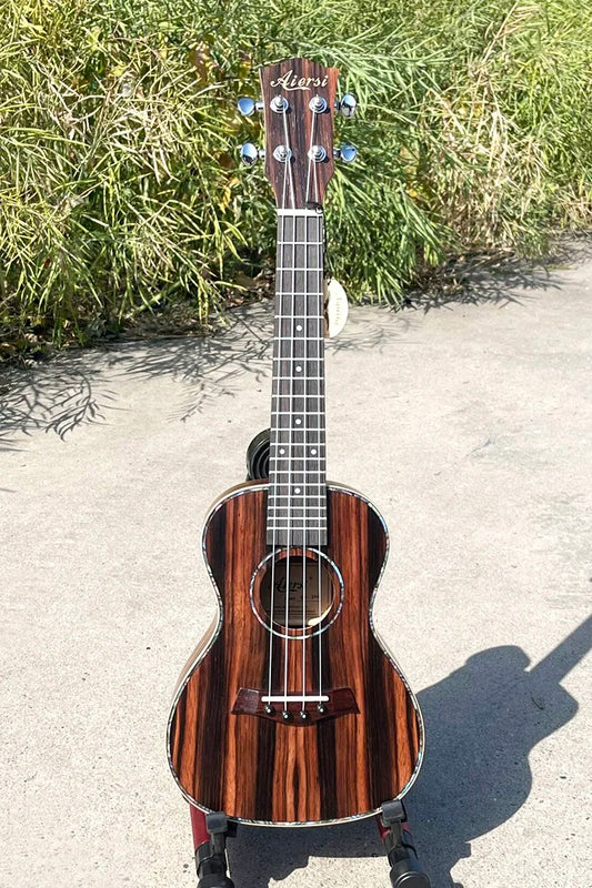 A sleek dark wood-finished java ebony concert ukulele by Aiersi with glossy striped grain at wholesale price made in China