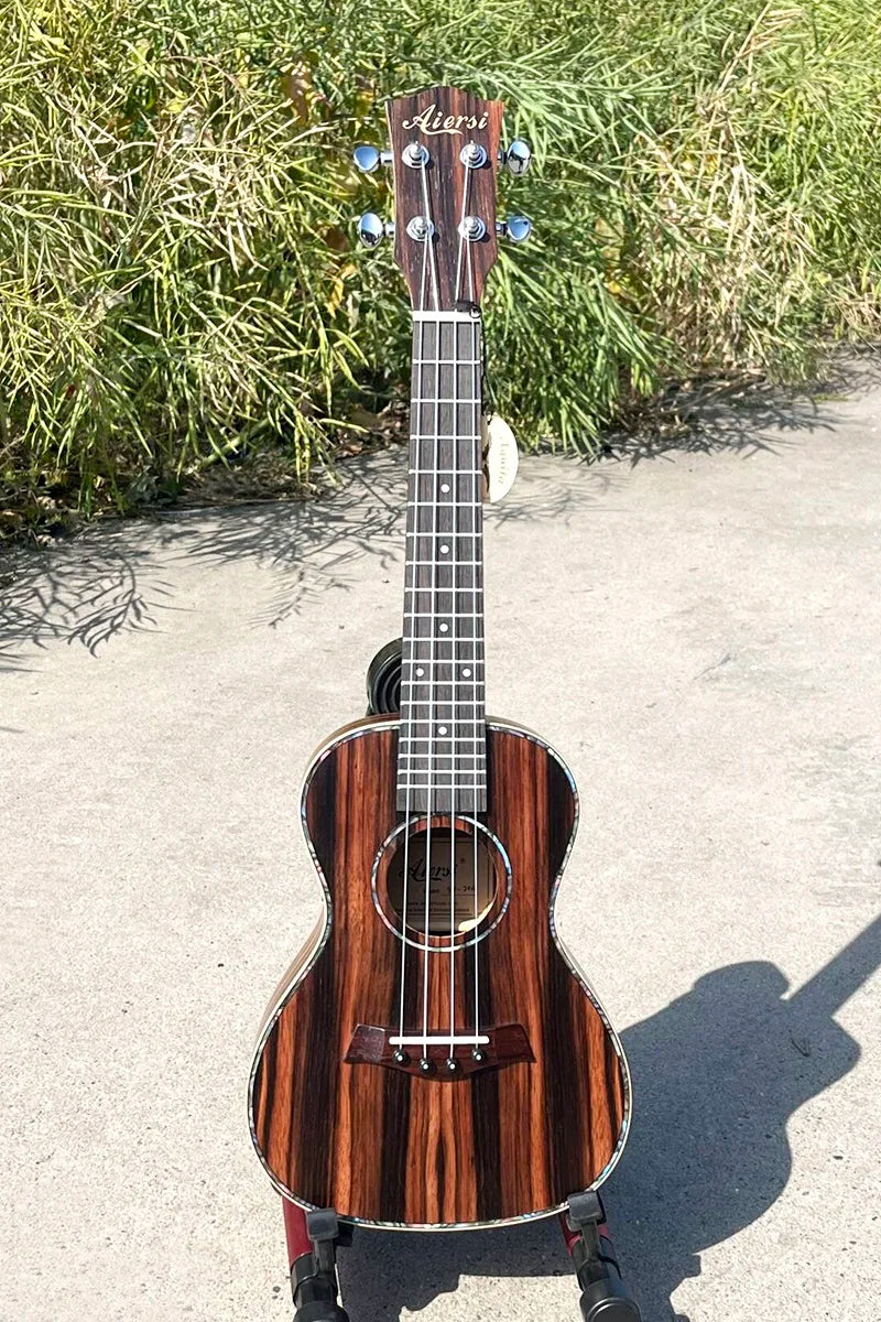 A sleek dark wood finished java ebony concert ukulele with glossy surface and striped grain wholesale price aiersi china string instrument