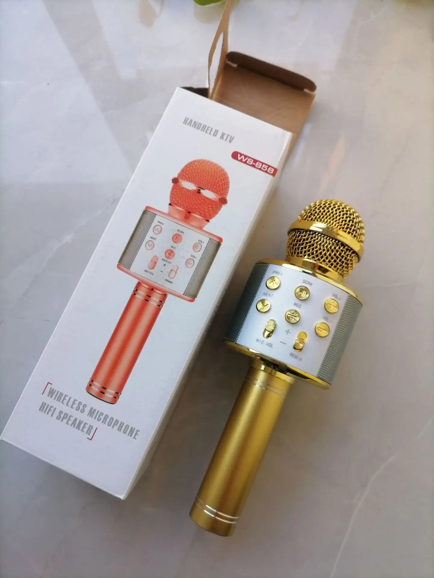Gold-colored wireless bluetooth k12 microphone with mesh grille control buttons and integrated speaker for portable party use