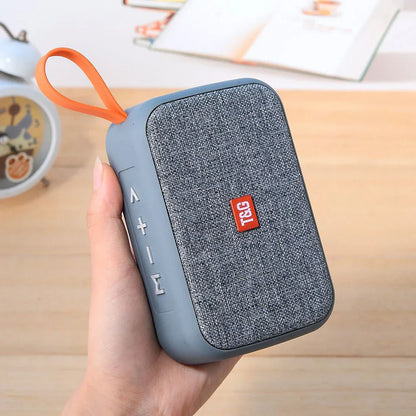 Gray textured fabric wireless bluetooth speaker with orange loop and red t&g logo radio fm waterproof small subwoofer sound