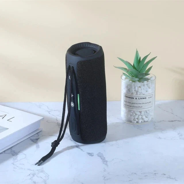 Black cylindrical wireless portable bluetooth speaker with textured fabric, carrying strap, radio fm subwoofer, audio hand free features