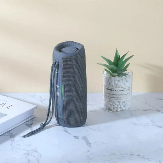 Gray cylindrical wireless portable bluetooth speaker with textured mesh exterior, carrying strap, radio fm subwoofer, audio hand free