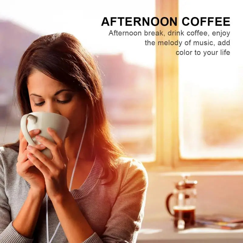 A white ceramic coffee mug with smooth glossy finish and curved handle next to 3.5mm wired in-ear earphone high sound quality gaming music video headset for samsung phone