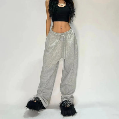Gray heathered sweatpants with drawstring waist and loose tapered legs in a woman american hip hop wide leg joggers style