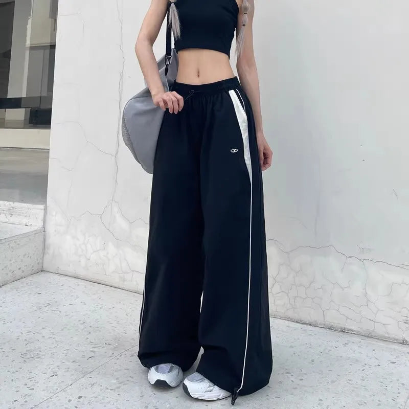 Black women casual joggers with white side stripes and embroidered logo featuring oversized sports wide leg design
