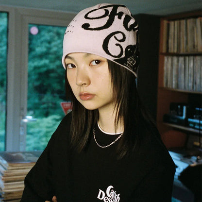Women’s pink knit hip hop beanie with black cursive lettering and perforated details for y2k hats streetwear