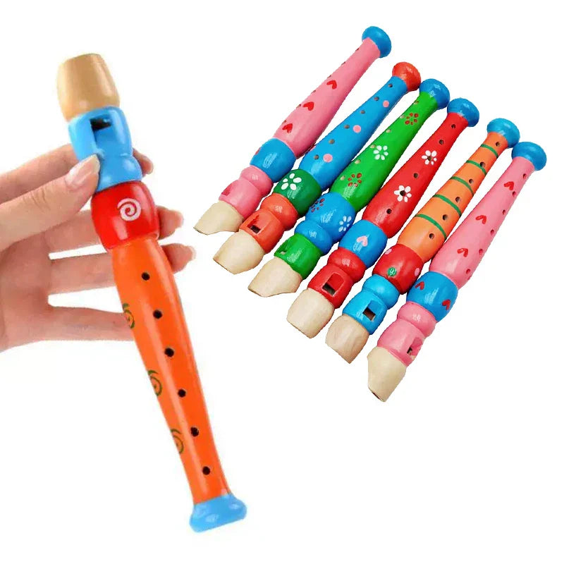 A hand holds a brightly colored wooden cartoon piccolo with orange body blue accents and black spiral patterns for early music education