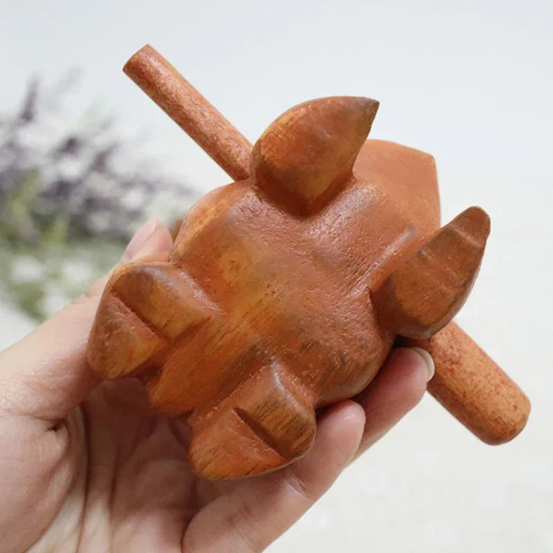 A smooth light brown wooden lucky frog croaking musical instrument with carved details and two handles for decor or toy