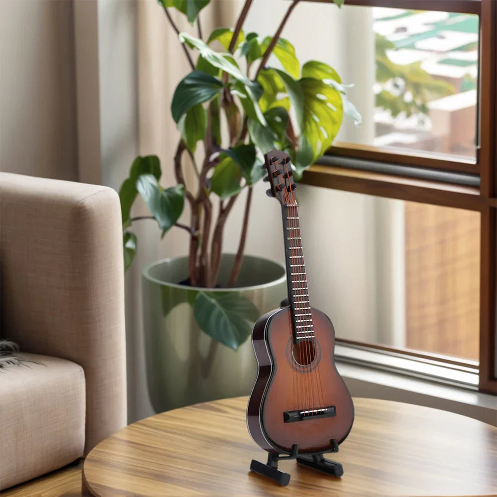 A small brown wooden miniature guitar with glossy finish and black hardware on wooden table for desk decoration