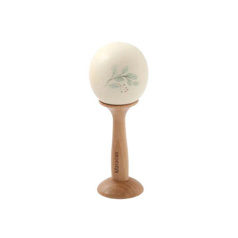 Cream-colored ceramic maraca with green leaf design on wood stand wooden musical instruments baby montessori toy